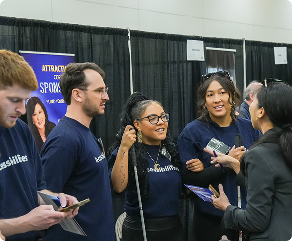 Accessibilities team members speaking with attendee about accessibility compliance solutions1
